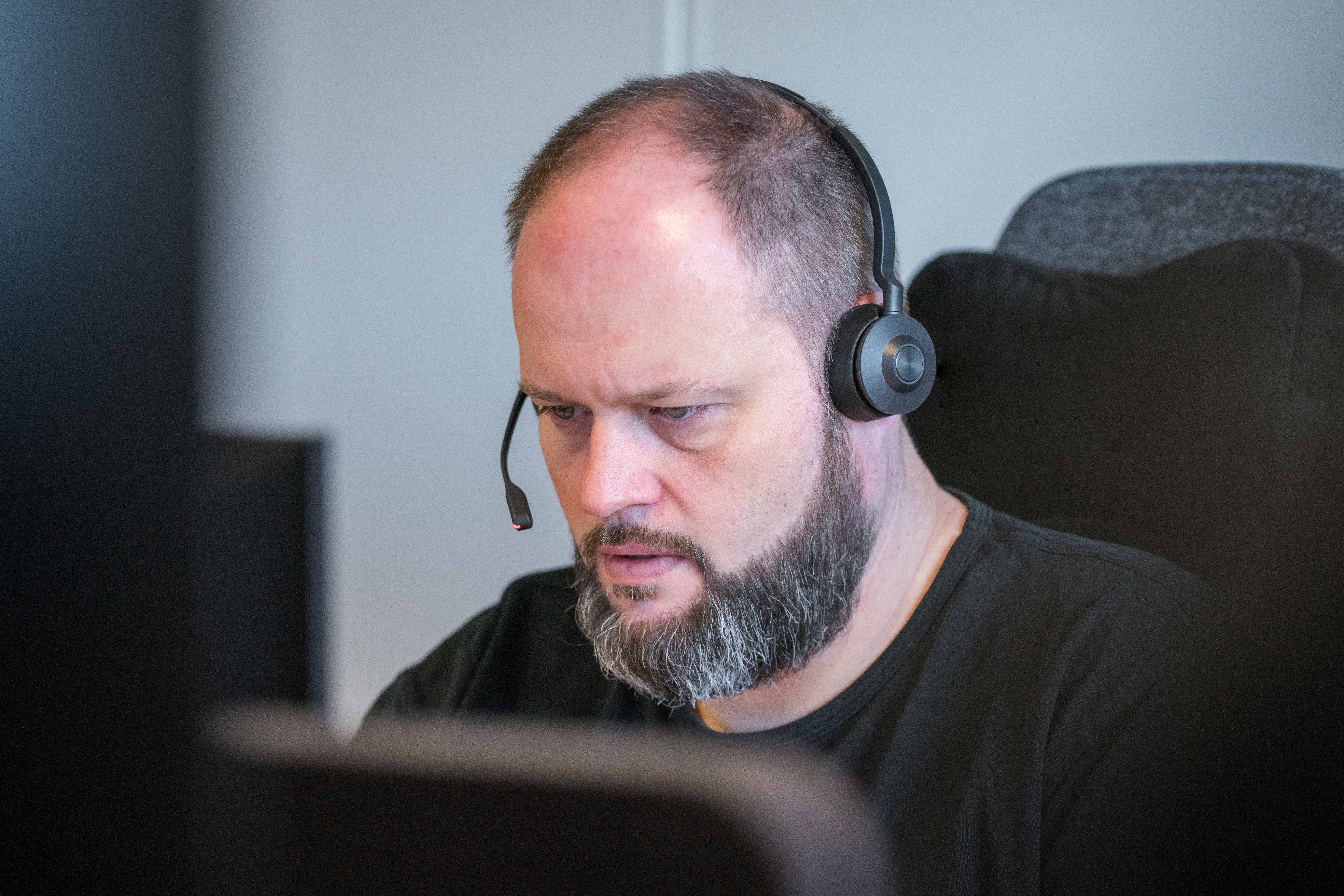 Mand snakker i headset i kontaktcenter